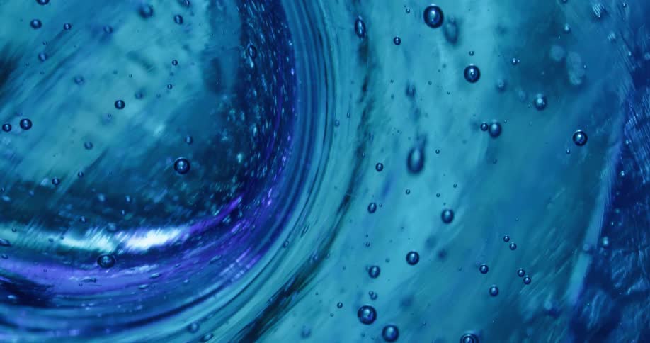 Air bubbles form in a clear blue liquid