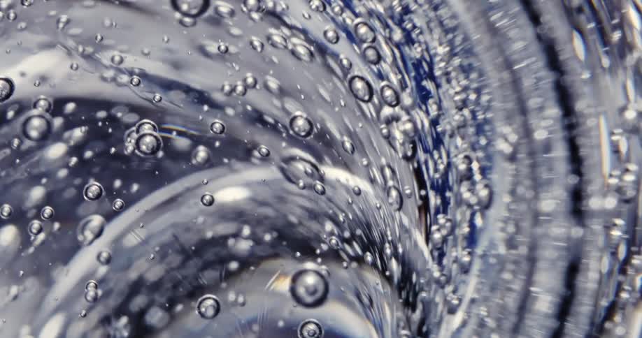 Close up of waves of thick blue translucent gel swelling and bubbling up