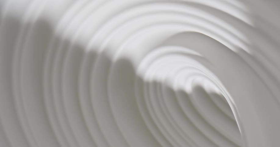 Light shines on a white swirling substance as it spins into a tunnel