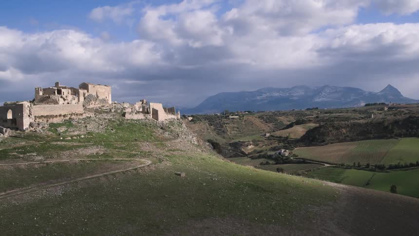 Stone buildings sit on the top of a hill