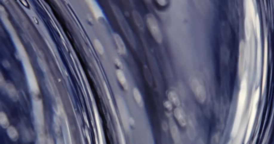 Ripples and air bubbles move through thick water