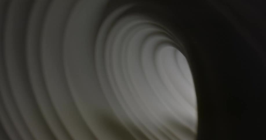 A tunnel of white pleated circles brightening then going dark