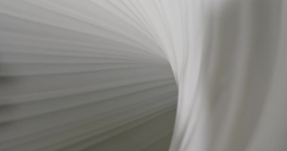 Light shines on a white swirling substance as it spins into a tunnel and becomes dark as the shadows move and grow