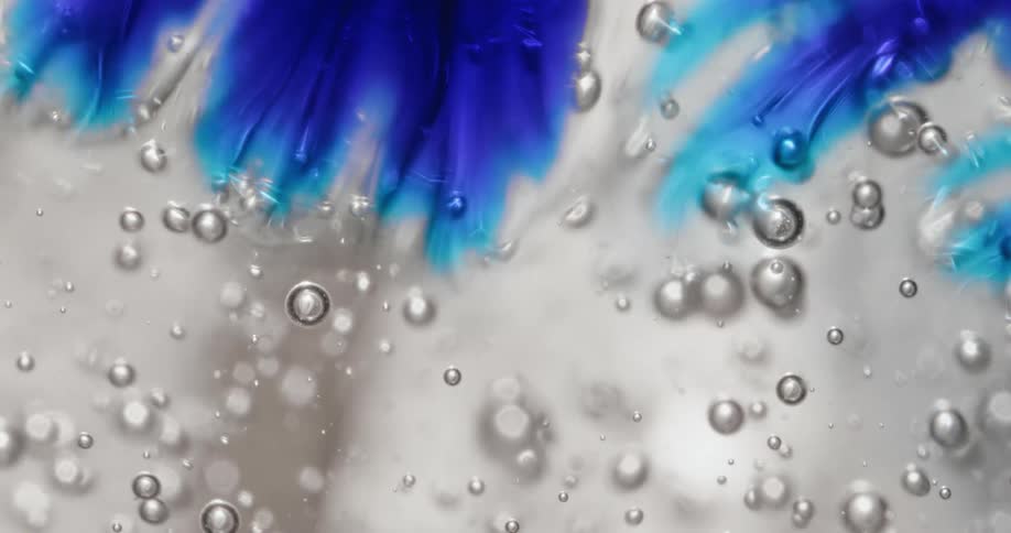 A blue dye struggles to spread in a thick clear liquid