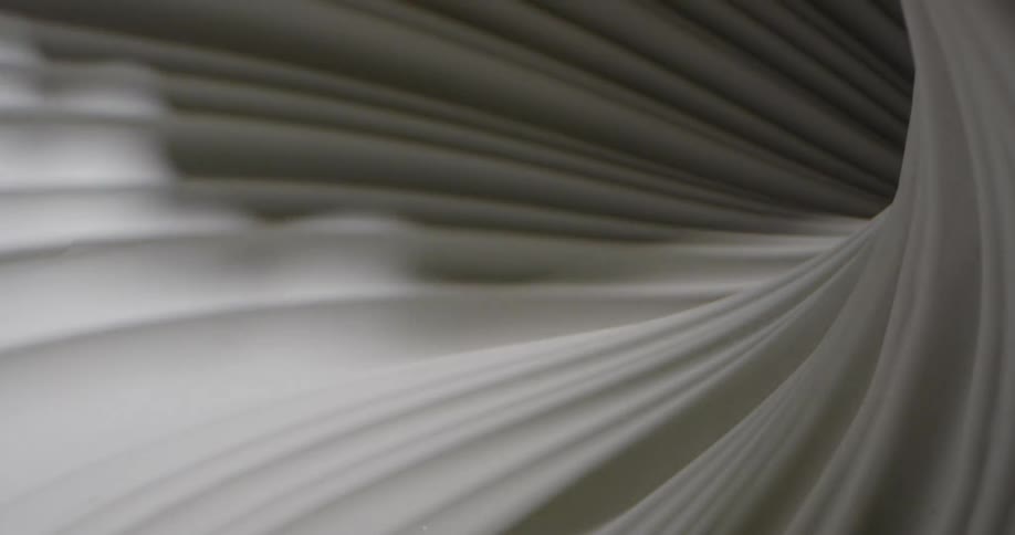 Shadows and light cast over a moving spinning surface of white fabric