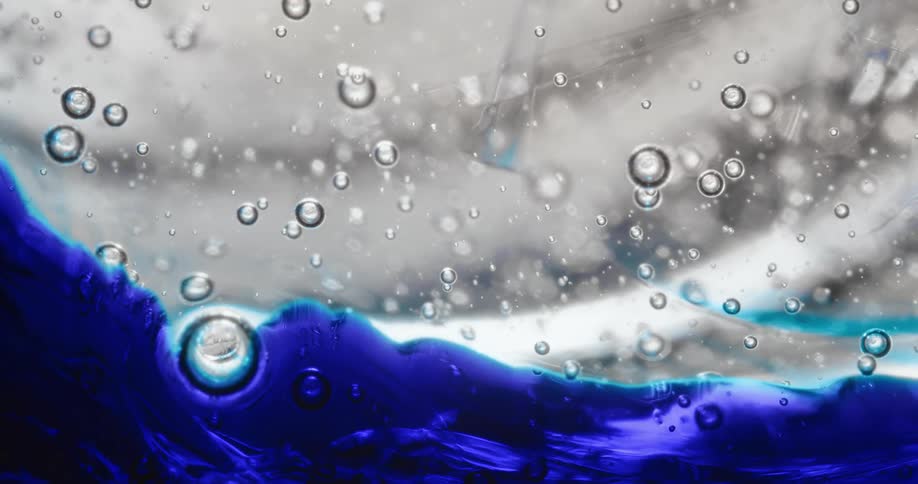 Liquid with blue dye and bubbles moves