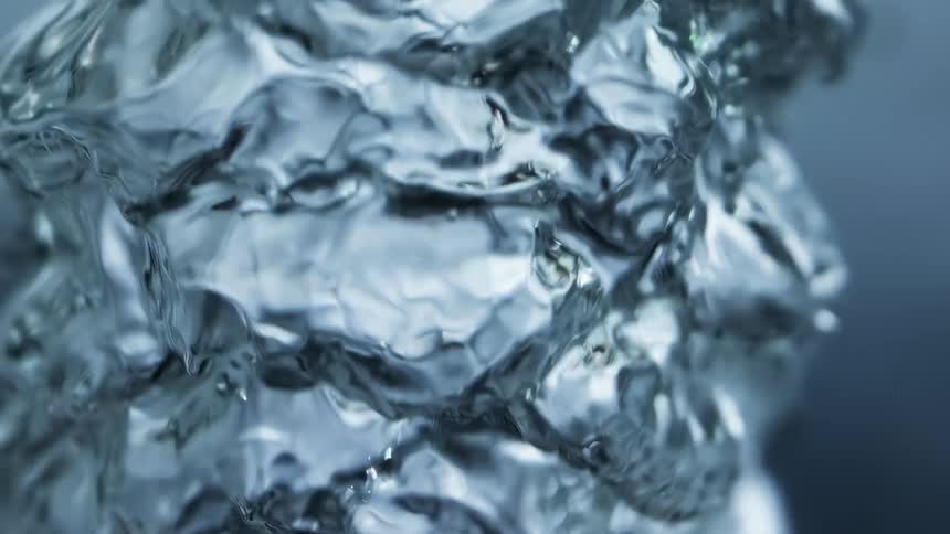 Poured water creates a ripple effect on water in a container