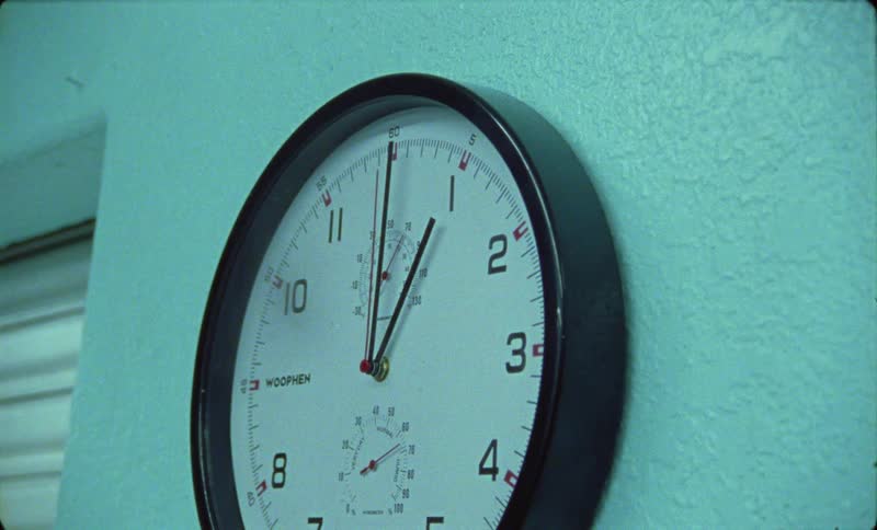 The hands of an analog clock on the wall move
