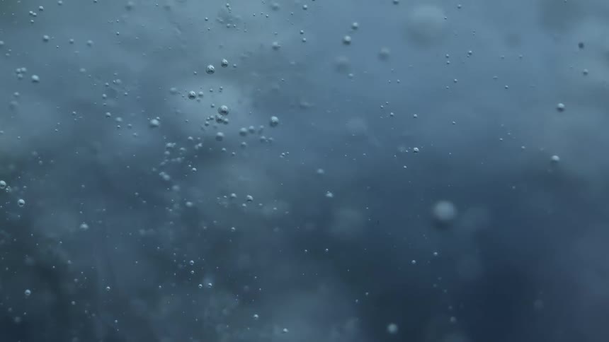 Close up of air bubbles floating up and down water