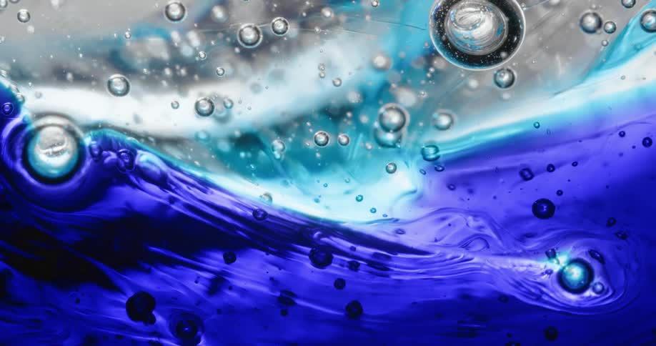 Close up of waves of thick blue translucent gel swelling and bubbling