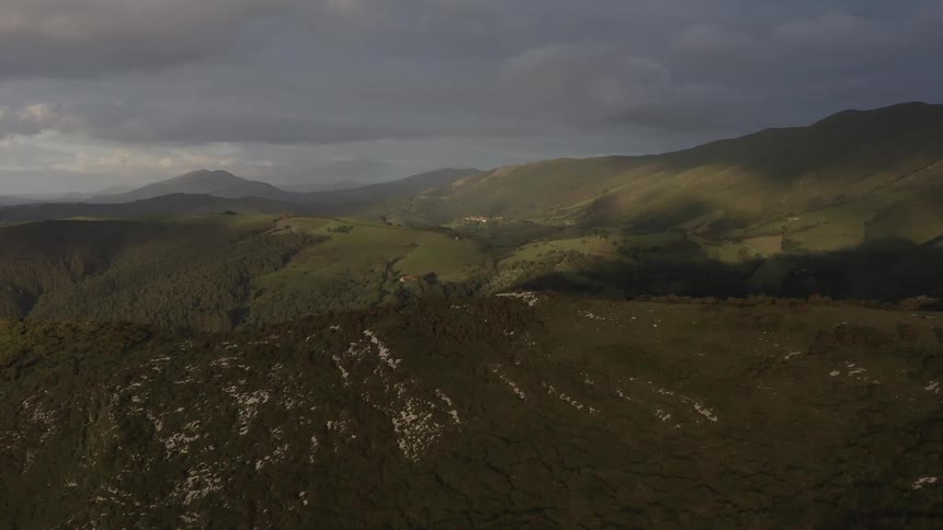 Fog starts to settle over the Cantabrian mountain range covered in lush green vegetation
