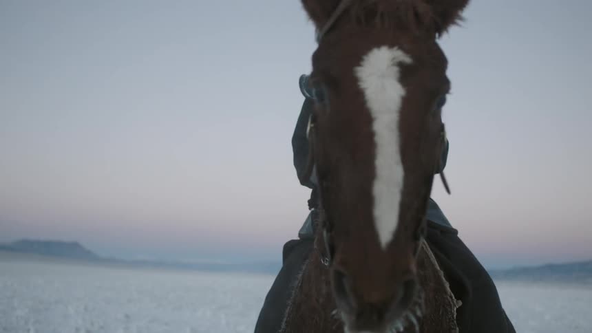 A man gets on his horse
