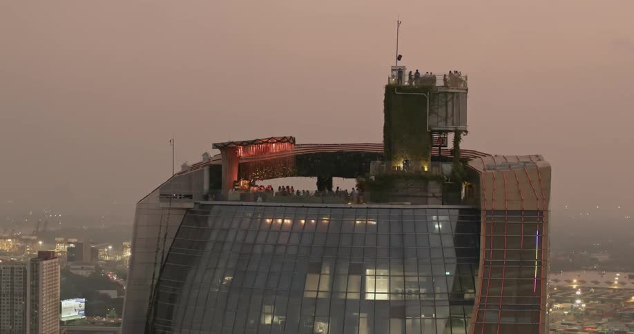 People move about rooftop establishment on skyscraper on densely foggy day