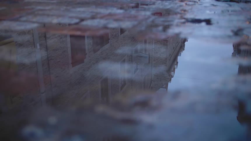 The building is reflecting on the puddle