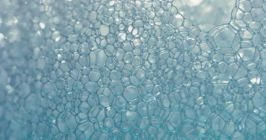 Comb of small blue soap bubbles popping and moving