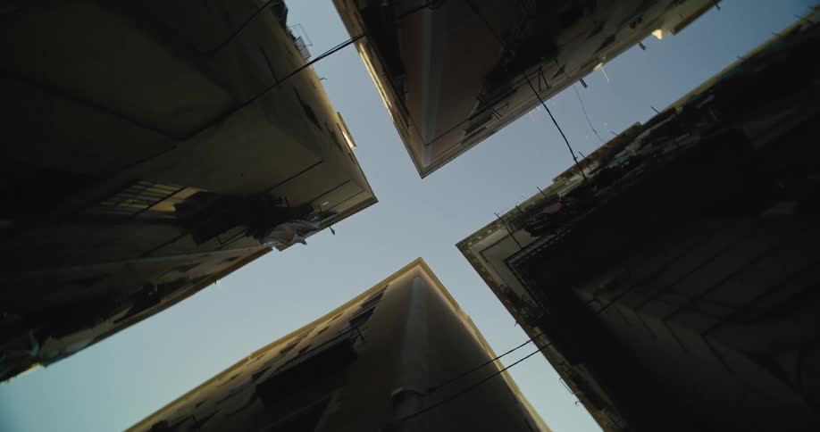 Corners of closely placed buildings show a cross shaped view of the sky
