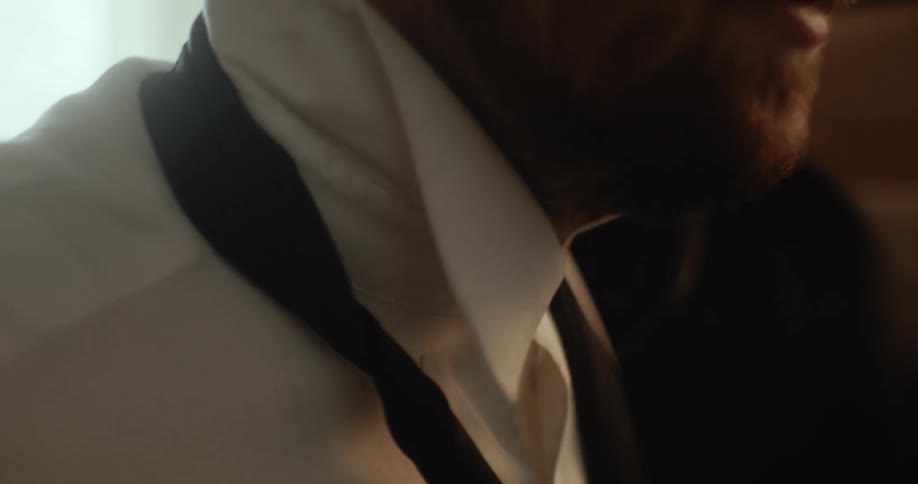 A man putting on a tie and jacket