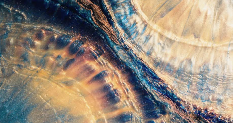Waves of bright colorful liquid ink flowing and converging on a dark blue stream