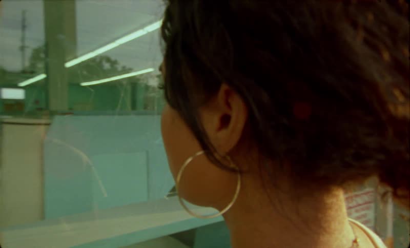 A woman looks through the front window of a laundromat