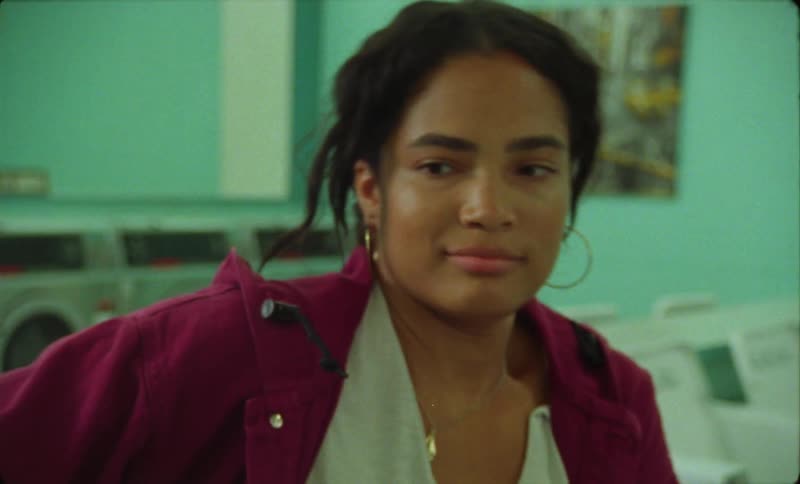 There is a young hispanic woman hanging out at the laundromat