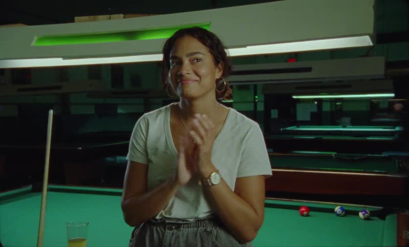 A woman claps in the pool hall