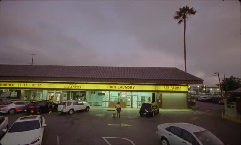 Exterior view of laundry and car park at dusk