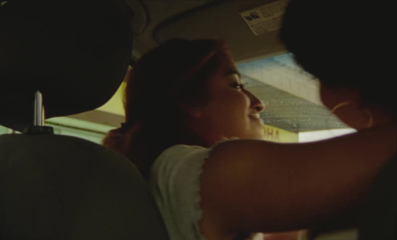 Two friends are hugging each other inside of a car