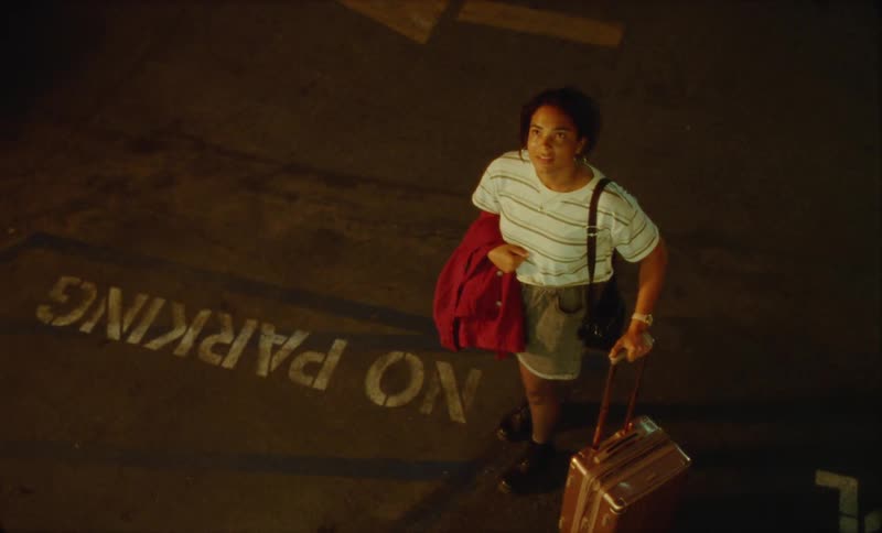 A young hispanic woman is walking outside at night time