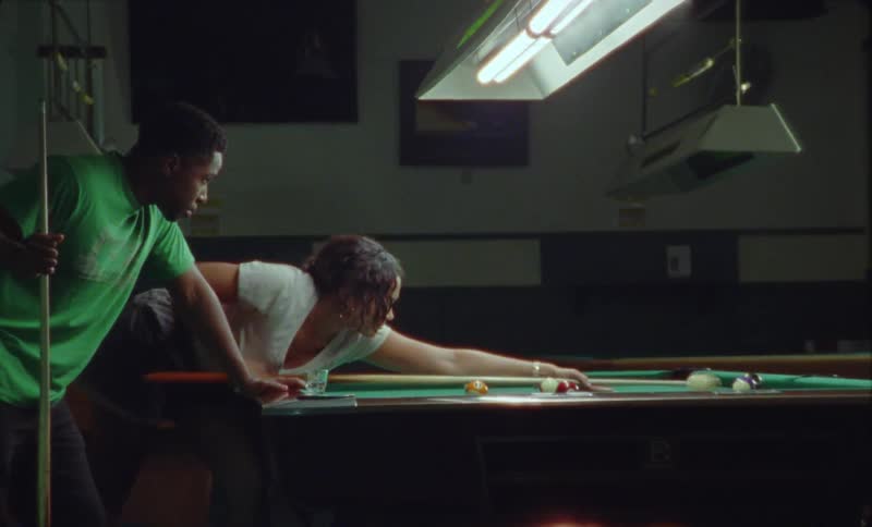 Young happy couple have fun with each other playing billiards on a pool