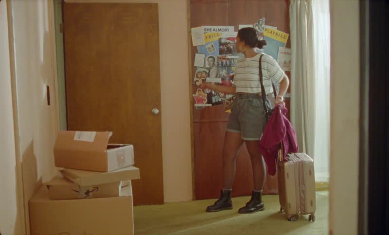 A young hispanic woman is walking indoors with her luggage