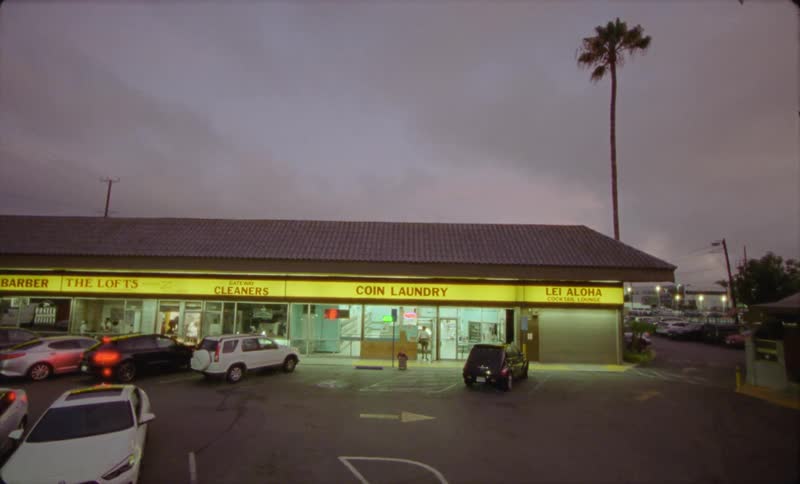 Exterior view of laundry and car park at dusk