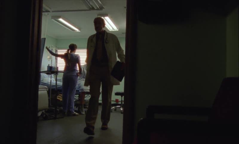 Doctor leaves the room where a nurse is taking care of a patient in the hospital