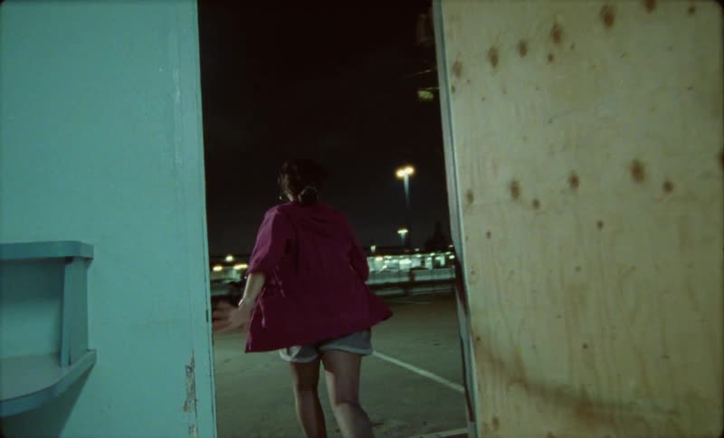 Young woman turns off the lights on a room and runs out the building to the parking lot