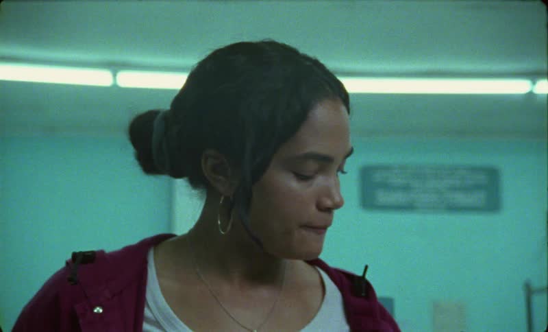 Woman with wavy hair hoop earrings drinks can of coca cola