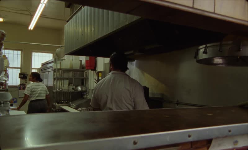 There are two people working at a restaurant in the day time