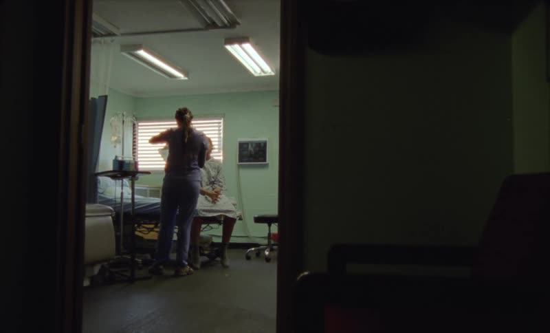 A nurse hangs an iv bag near a patient
