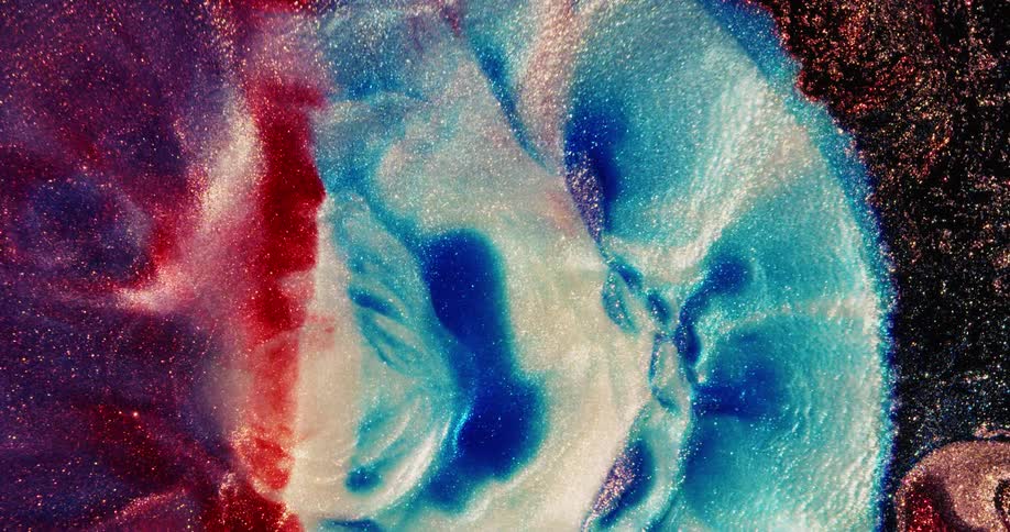 Glittery shiny colorful liquid ink bursts expandingand blooming in a sudden wave