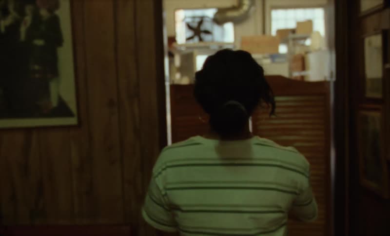 A woman walking through a restaurant and kitchen