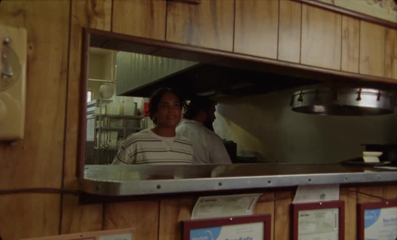 There is a waitress and a cook working at a restaurant