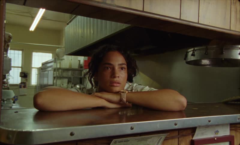 A female restaurant employee staring from the kitchen