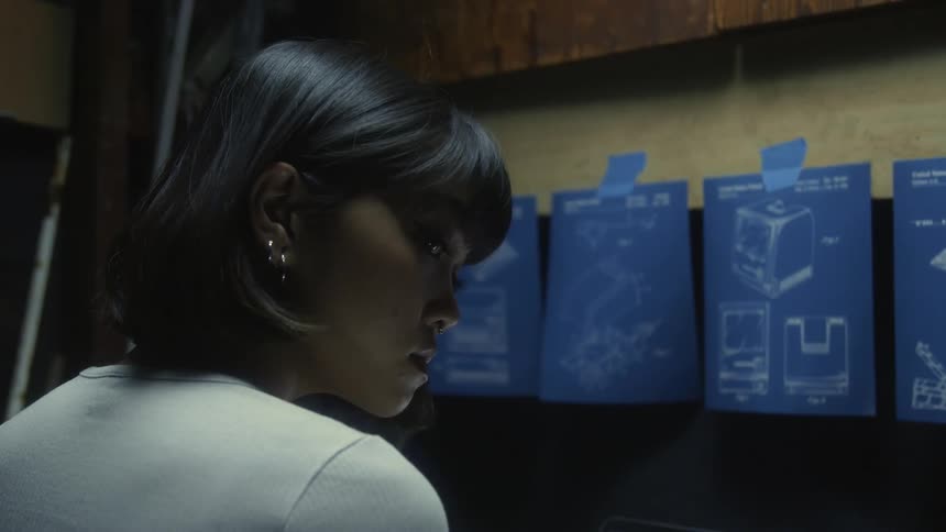 A woman is looking down at something then turns her head to the side