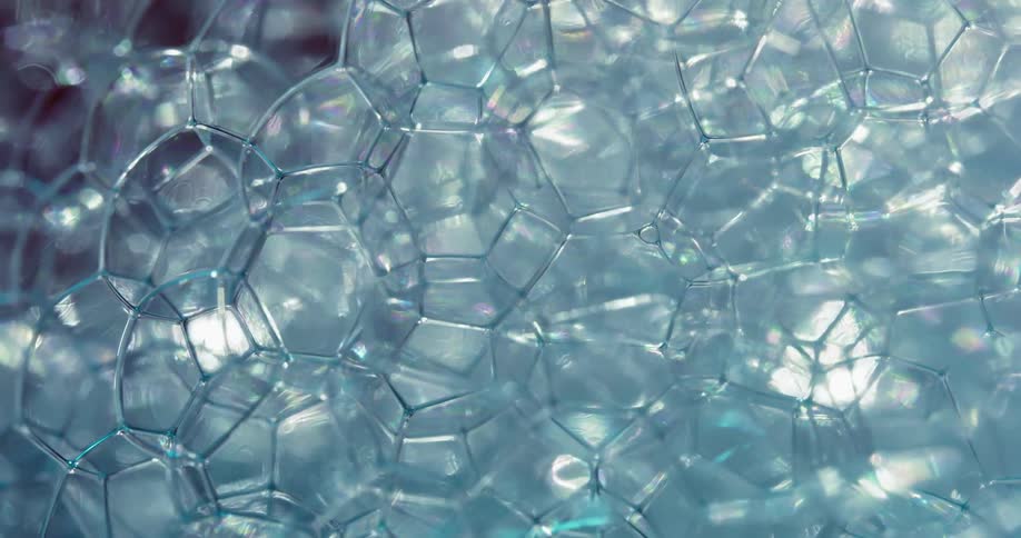 A bubble substance reflects light as it moves and the sections of bubbles grow and others pop