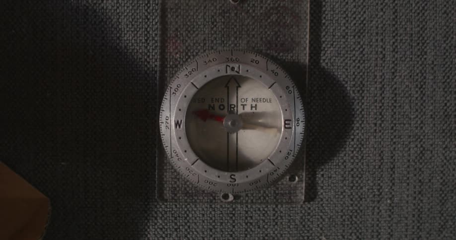 Person place compass on surface and needle moves back and forth in it