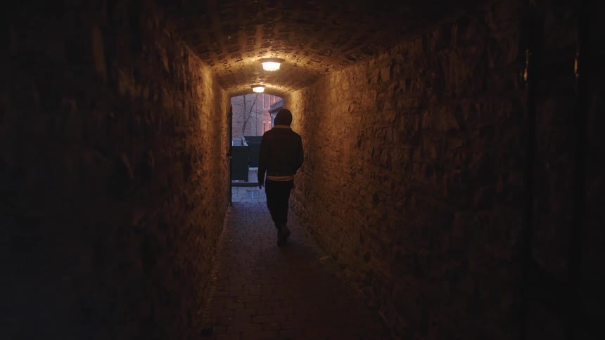 There is a man walking inside of a building in the day time