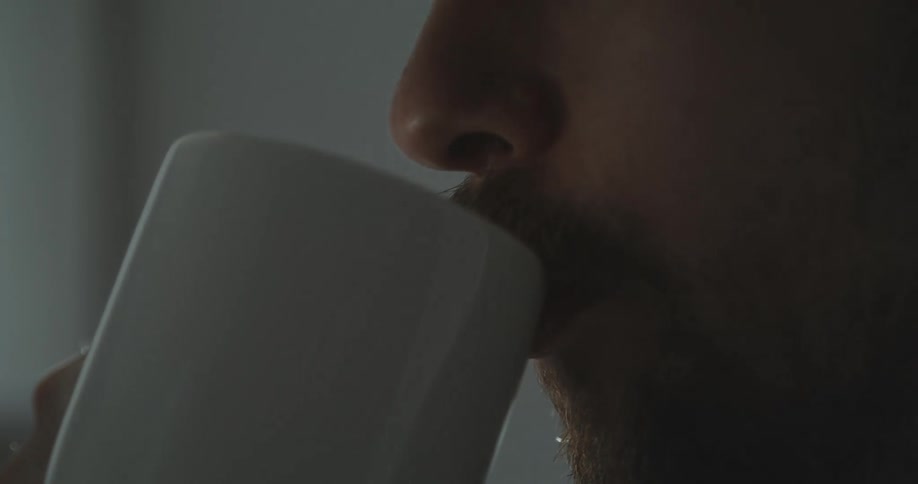 There is a white man that is drinking coffee out of a cup
