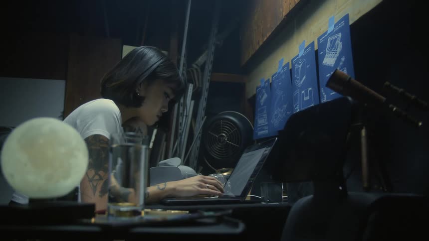 A woman is sitting at a desk typing on a computer