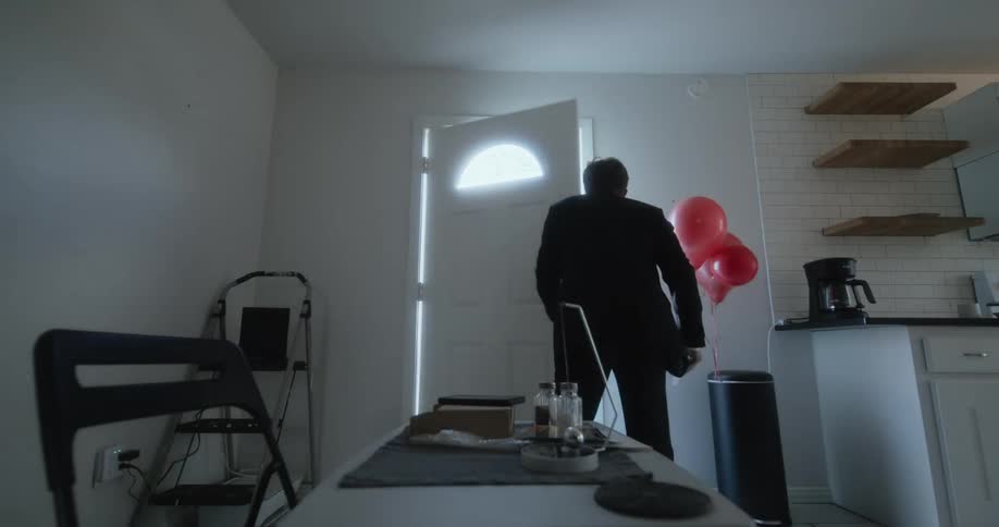 A man grabs his keys and exits his home