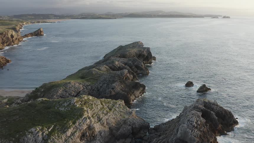 A bird flies over the jagged Atlantic shore in Northern Spain
