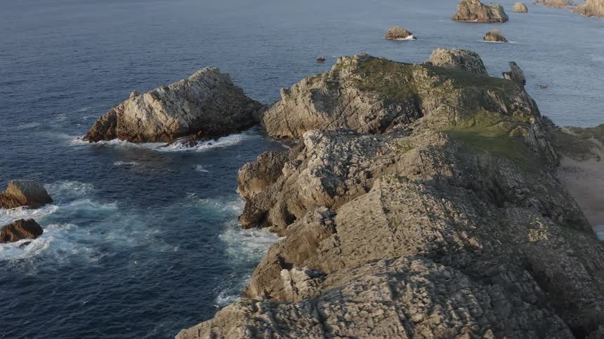 Waves splash as they crash against rocks along the Atlantic shoreline in the north of Spain