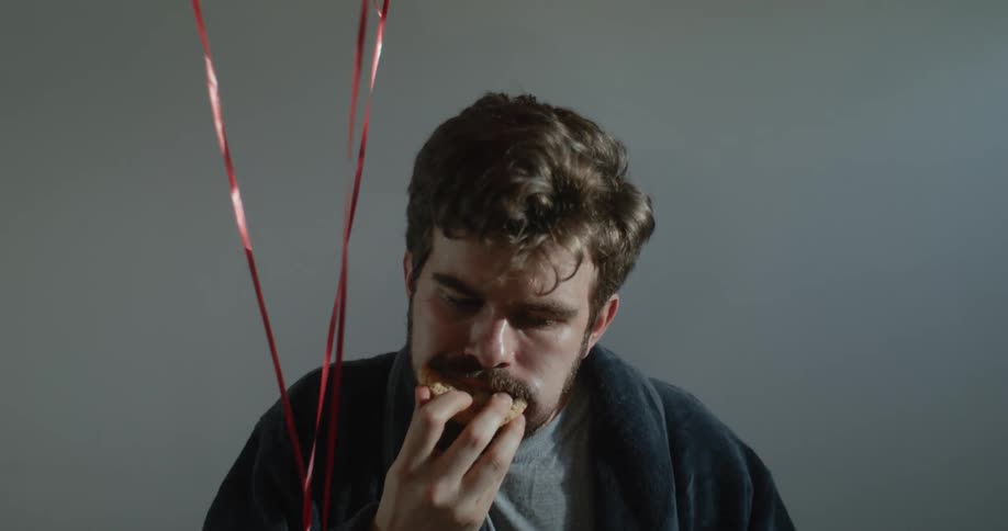 There is a white man that is eating a cookie very fast
